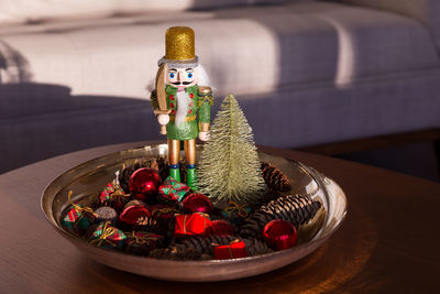 Nutcracker soldier decoration standing as centrepiece on coffee table in bowl of decorations