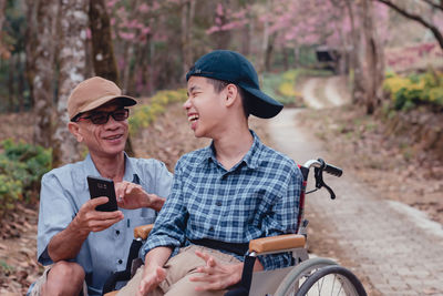 Young man using smart phone while sitting outdoors