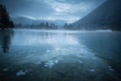 Scenic view of lake against sky during winter