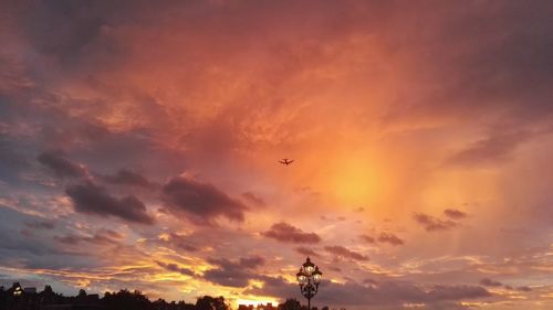 Low angle view of silhouette birds flying against sky during sunset