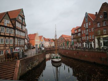 Canal amidst buildings against sky