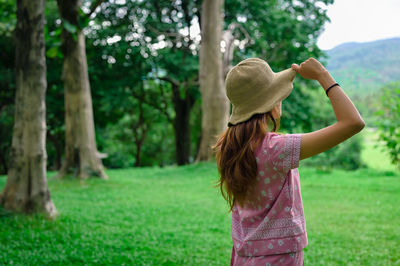 Back view point of young women wearing hat and looking at far away 