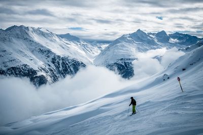 Scenic view of snowcapped mountain against cloudy sky