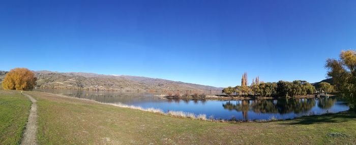 Scenic view of lake against clear blue sky