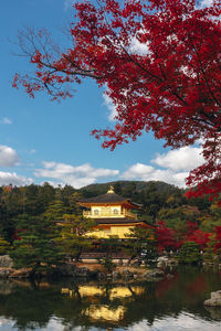 Scenic view of lake by buildings against sky during autumn