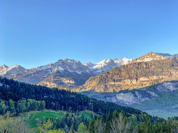 Scenic view of snowcapped mountains against clear blue sky