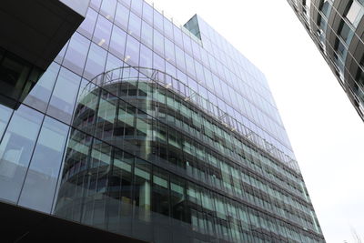 Low angle view of glass building against sky