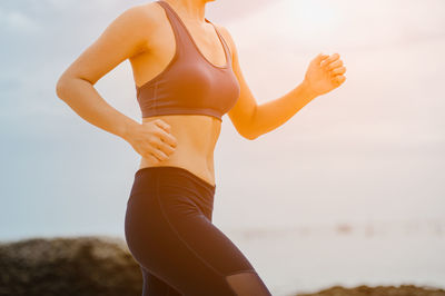 Midsection of woman standing against sky