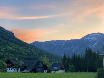 Houses by mountains against sky during sunset