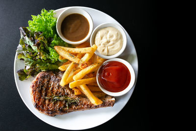 Grilled meat, porkchops steak with pepper sauce and salad.