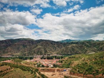 Scenic view of village against cloudy sky