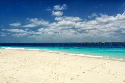 Scenic view of beach against blue sky