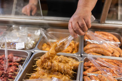 Midsection of person preparing food for sale in market