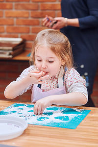 Close-up of girl sitting on table