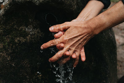 Cropped image of woman washing hand by running water