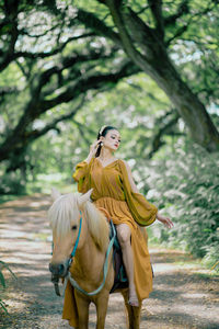 Portrait of young woman standing in park