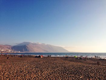 Scenic view of beach against clear blue sky