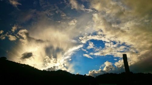 Low angle view of silhouette trees against sky