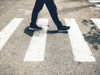 Low section of man standing on road