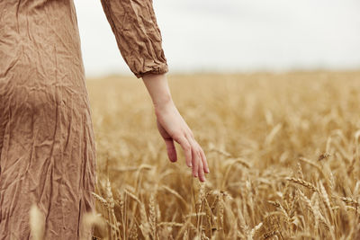 Midsection of woman standing on field