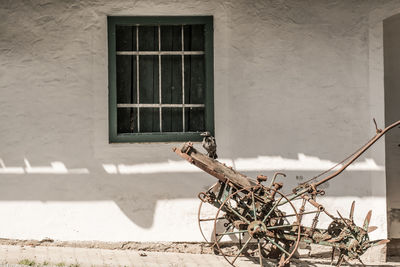 Bird perching on damaged wagon outside house