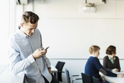 Young man using smart phone in classroom