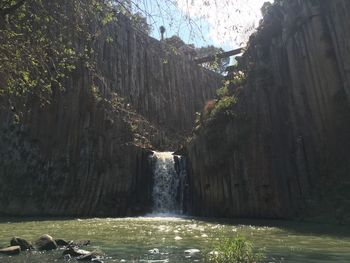 Scenic view of waterfall against sky