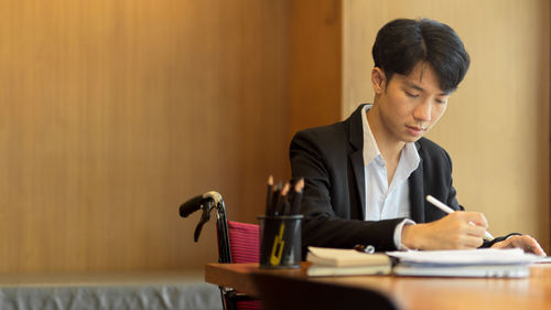 Mid adult man sitting on book