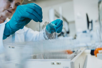 Scientist examining human brain microscope slide while standing at laboratory