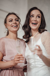 Bridesmaid and bride holding champagne flute