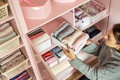 High angle view of woman keeping clothes in drawer