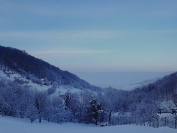 Scenic view of snow covered field against sky