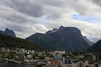 Townscape by mountains against sky