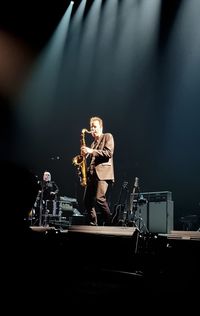 Man with arms outstretched at music concert