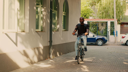 Side view of man riding bicycle on street