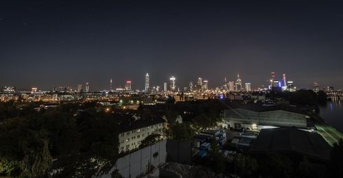 Illuminated cityscape against sky at night