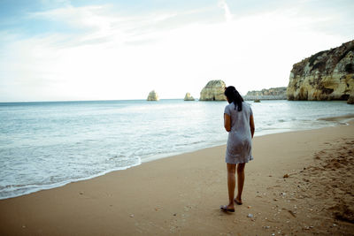 Rear view of woman standing on beach