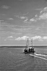 Sailboat sailing on sea against sky