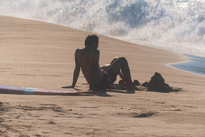 Man sitting on shore at beach