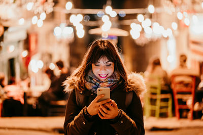 Portrait of young woman using smart phone outdoors