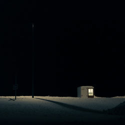 Snow covered houses against clear sky at night