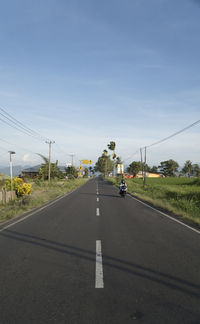 Vehicles on road against sky