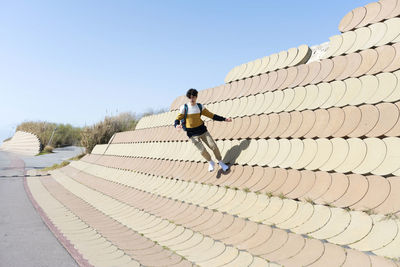 Young man jumping on the urban wall background