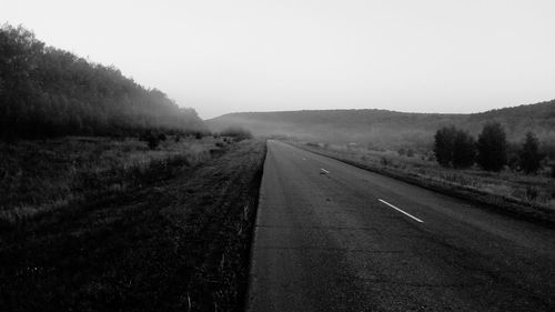 Road amidst agricultural field against clear sky