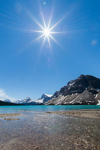 Scenic view of mountains against blue sky during winter