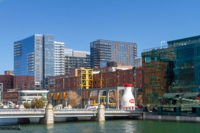 River by buildings against clear sky in city