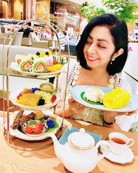 Portrait of smiling woman with food on table