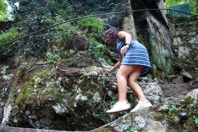 Full length of man on rock in forest