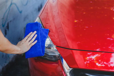 Close-up of hand holding red car