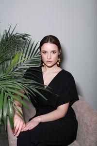 Portrait of smiling young woman with eyes closed against wall